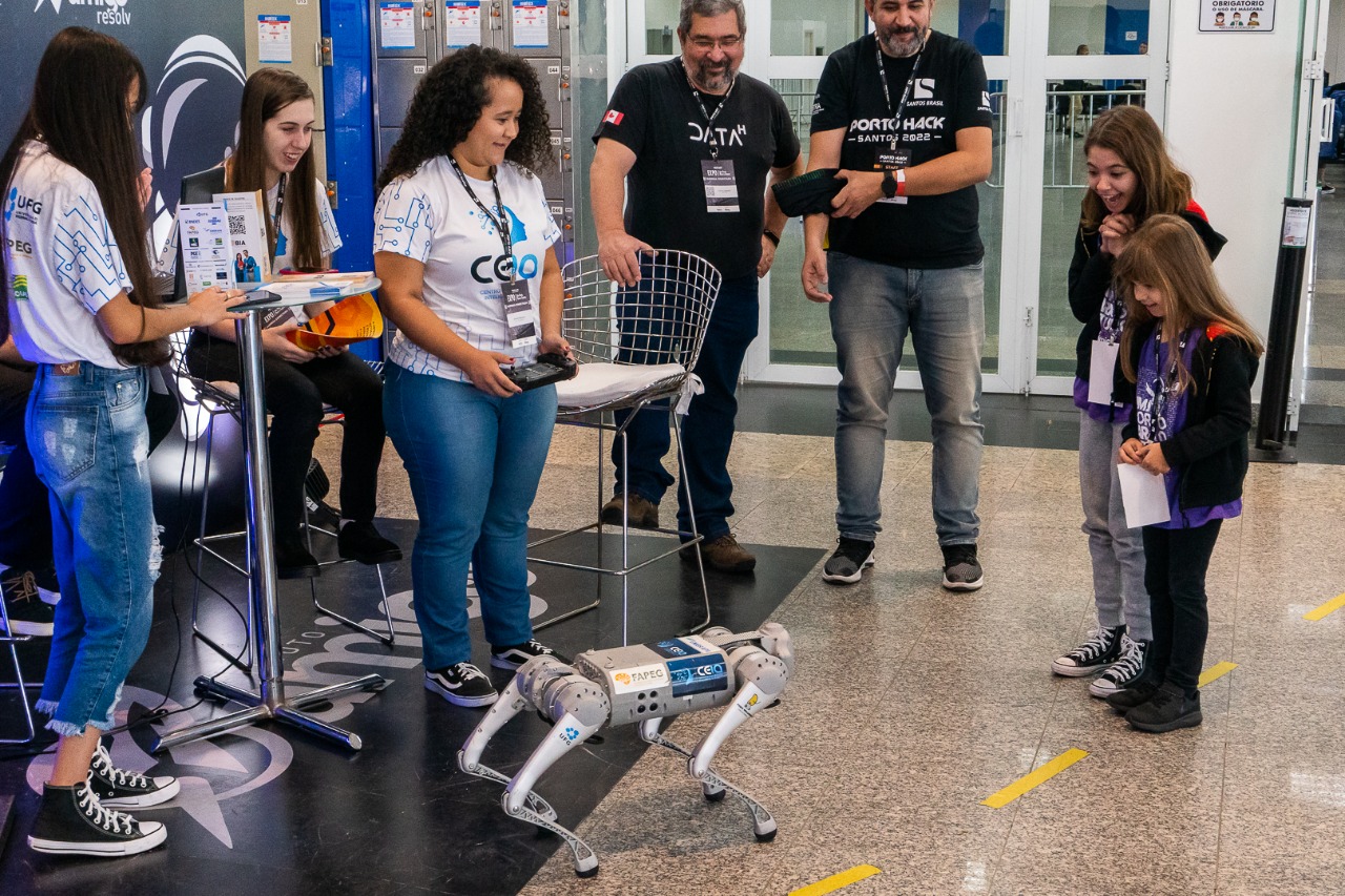 Estudantes e mentores demonstrando um robô quadrúpede no Porto Hack Santos